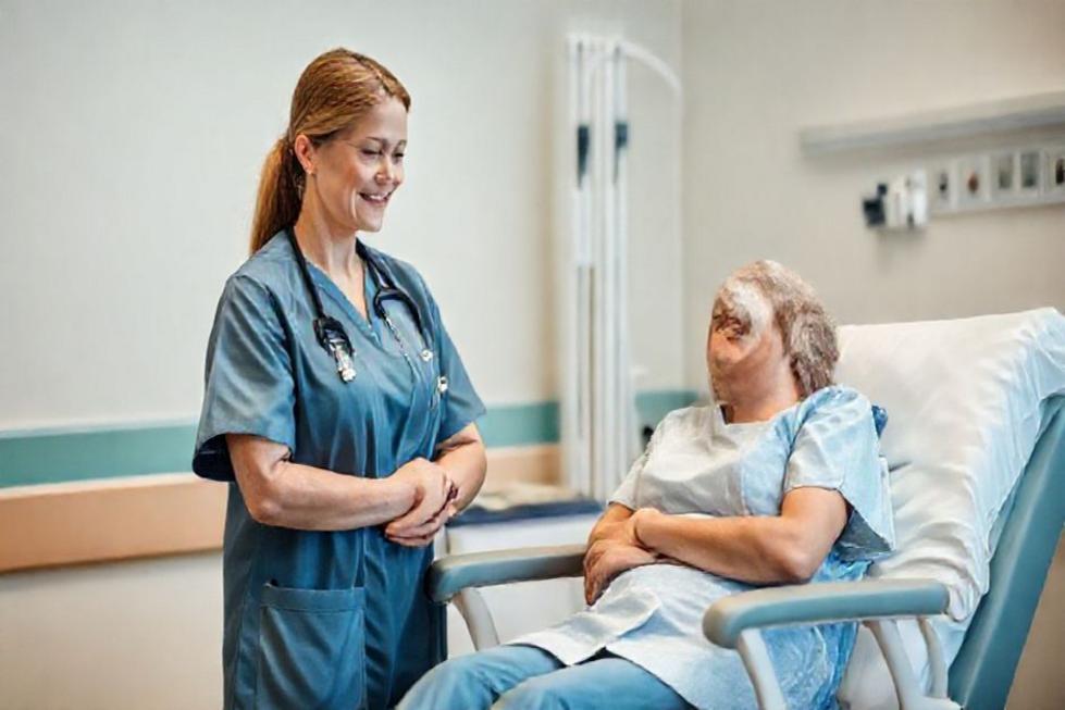 Profissional de saúde ao lado da cadeira de quimioterapia, pronto para oferecer apoio.